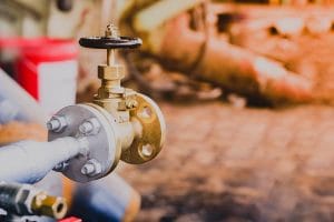 globe valve connected to steel pipe in factory representing a type of utility compliance consulting