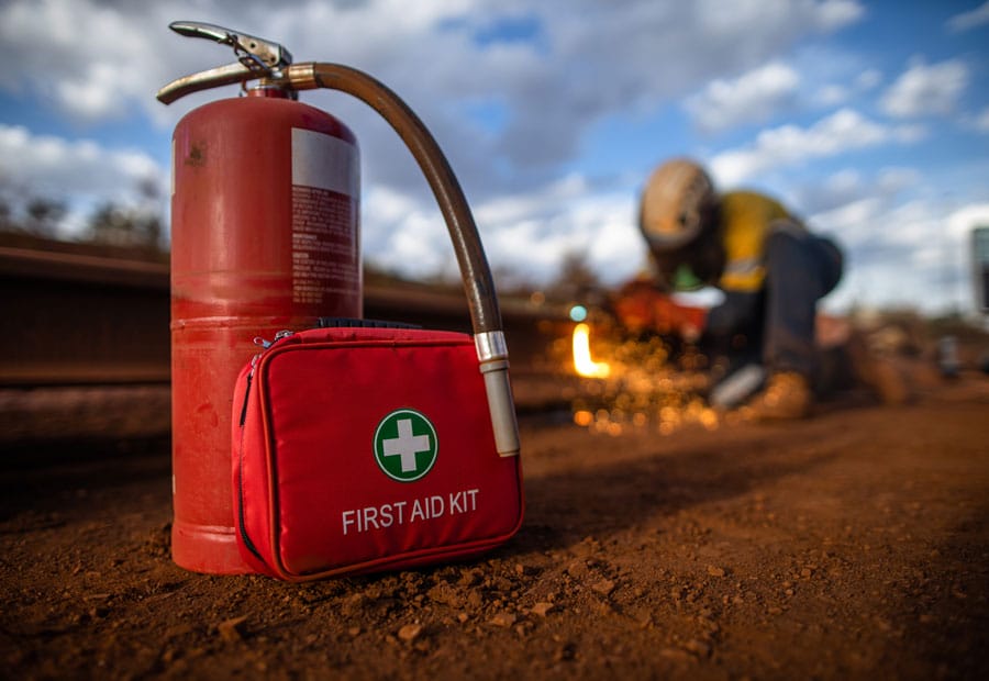 fire extinguisher and first aid kit with worker performing hot work