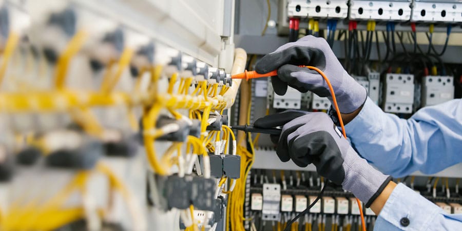 worker testing electrical circuits wearing gloves