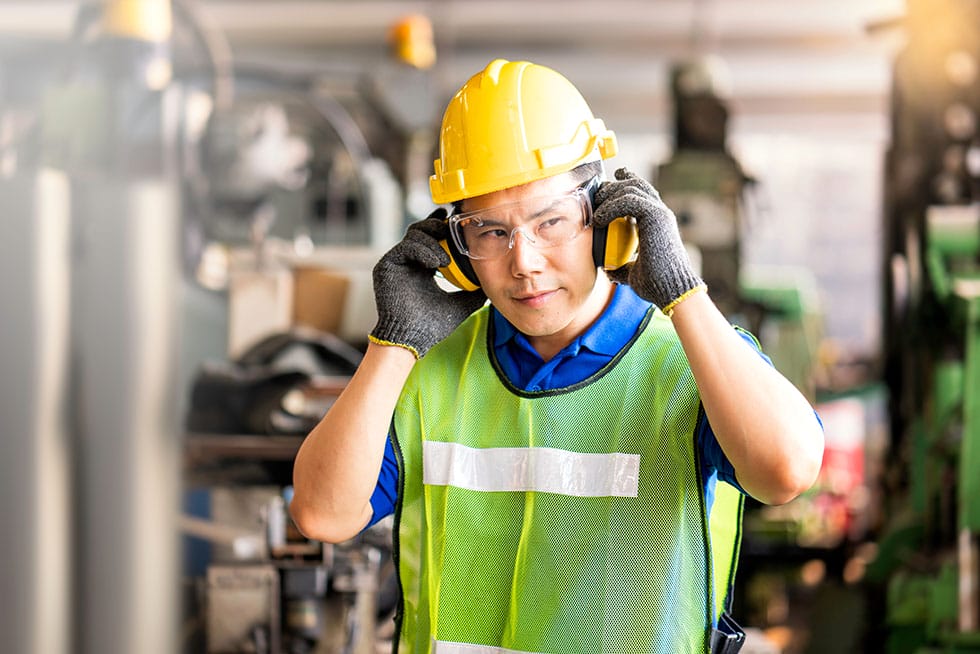 worker wearing various personal protective equipment at a construction site